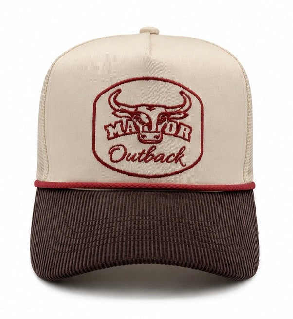 A trucker-style baseball cap with an off-white front panel and dark brown mesh back, featuring a brown corduroy brim. The front panel has an embroidered logo of a bull head inside an oval with the text 'MAJOR Outback' in brown.