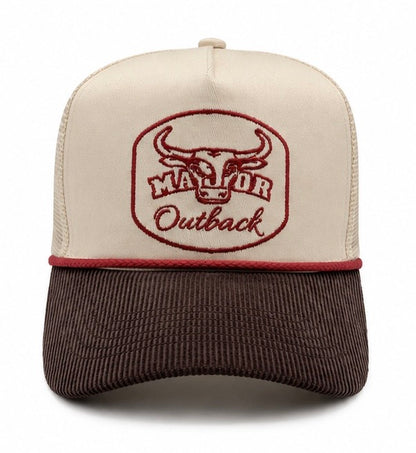 A trucker-style baseball cap with an off-white front panel and dark brown mesh back, featuring a brown corduroy brim. The front panel has an embroidered logo of a bull head inside an oval with the text 'MAJOR Outback' in brown.
