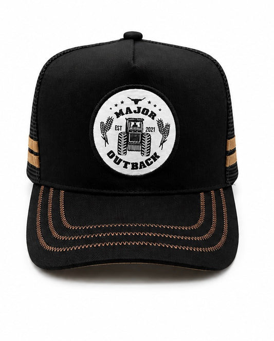 A black trucker-style baseball cap with a white circular front patch reading 'MAJOR OUTBACK EST 2021' around a tractor graphic, plus tan contrast stitching on the brim and side stripes, shown on a white background.